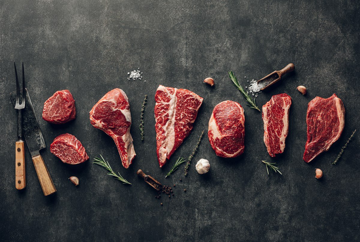 Raw beef cuts on a dark surface