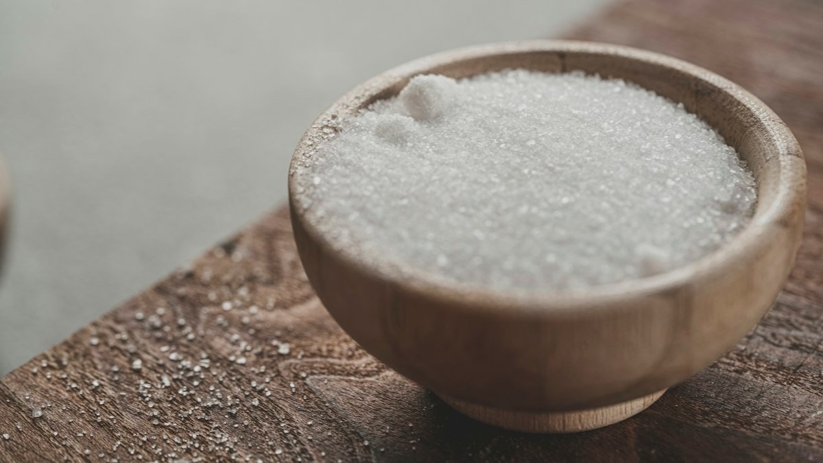 White granulated sugar in a wooden bowl